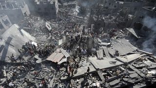 فلسطينيون يتفقدون أنقاض المباني المدمرة جراء الغارات الجوية الإسرائيلية على مدينة خان يونس جنوب قطاع غزة> 2023/10/26