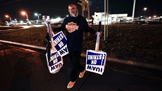 عضو اتحاد عمال سيارات يحمل لافتات الإضراب عند مصنع تجميع فورد ميشيغان في واين، ميشيغان، الأربعاء 25 أكتوبر 2023.