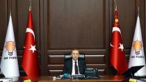 رجب طیب اردوغان، رئیس جمهوری ترکیه و رهبر حزب حاکم عدالت و توسعه در کنار پرچم‌های ترکیه و پرچم‌های حزب عدالت و توسعه در سال ۲۰۱۷