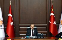 رجب طیب اردوغان، رئیس جمهوری ترکیه و رهبر حزب حاکم عدالت و توسعه در کنار پرچم‌های ترکیه و پرچم‌های حزب عدالت و توسعه در سال ۲۰۱۷