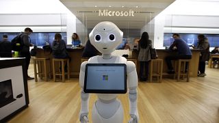 In this March 21, 2019 photo a robot called "Pepper" is positioned near an entrance to a Microsoft Store location, in Boston.