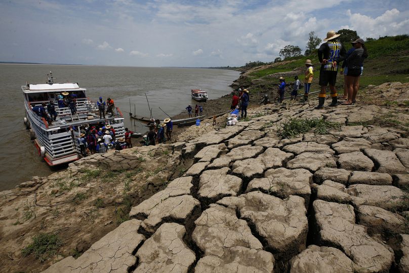 Residents of a riverside community carry food and containers of drinking water after receiving aid due to the ongoing drought in Careiro da Varzea, Amazonas state, 24 October.