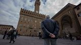An elderly man looks at the 14th-century town hall 'Palazzo Vecchio' (Old Palace) in Florence, Italy, Thursday, Feb. 17, 2022.