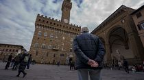 An elderly man looks at the 14th-century town hall 'Palazzo Vecchio' (Old Palace) in Florence, Italy, Thursday, Feb. 17, 2022.