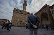 An elderly man looks at the 14th-century town hall 'Palazzo Vecchio' (Old Palace) in Florence, Italy, Thursday, Feb. 17, 2022.