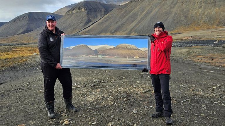 Project manager Morten H. Johansen at Store Norske and climate and environment minister Espen Barth Eide in today's Sveagruva with a picture of how it looked before.
