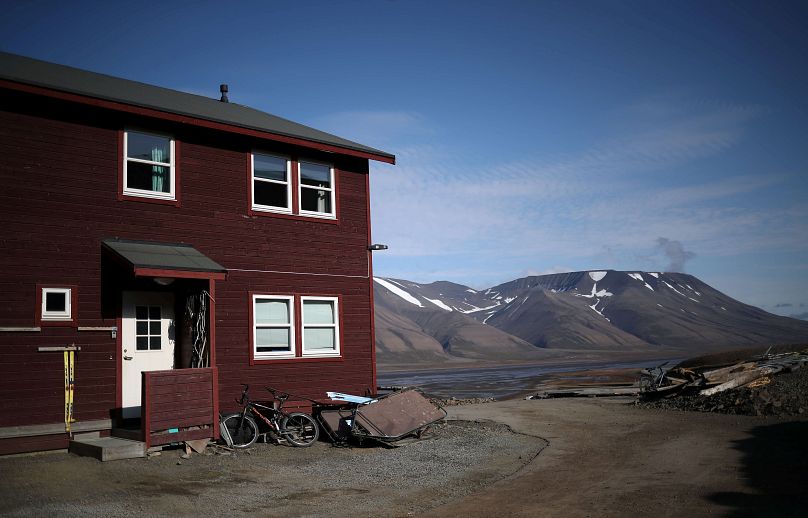 A residential house is seen in front of snow capped mountains in the town of Longyearbyen in Svalbard, Norway.