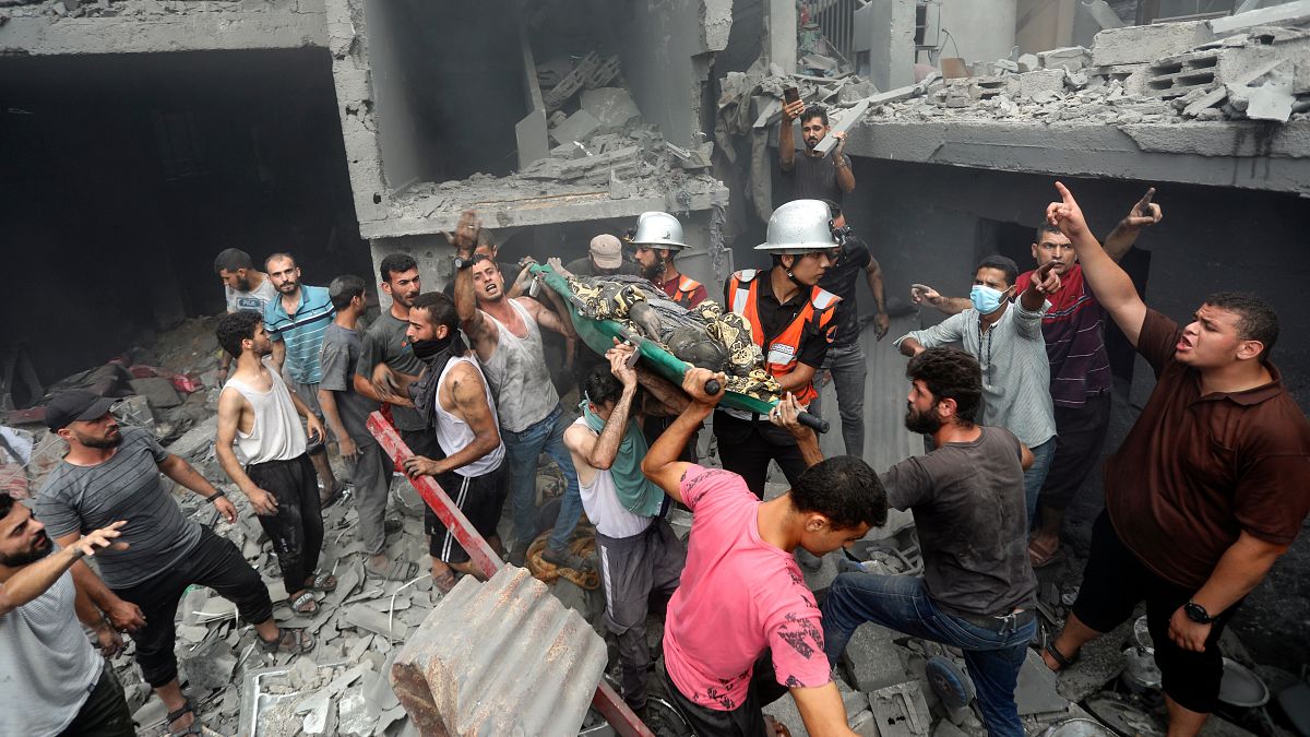 Palestinians carry a dead person who was found in the debris following Israeli airstrikes on Gaza City.