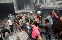 Palestinians carry a dead person who was found in the debris following Israeli airstrikes on Gaza City.