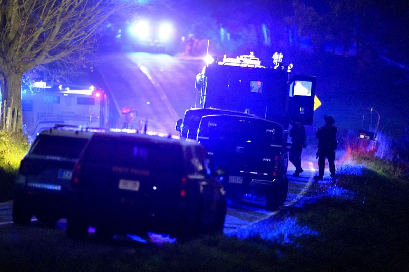 Αστυνομικοί στέκονται κοντά σε θωρακισμένα και τακτικά οχήματα, στο κέντρο, κοντά σε μια ιδιοκτησία στο Meadow Road, στο Bowdoin, Maine, Πέμπτη, Οκτ. 26, 2023.
