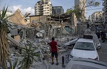 Homem olha para os escombros deixados pelos bombardeamentos de Israel, na Faixa de Gaza