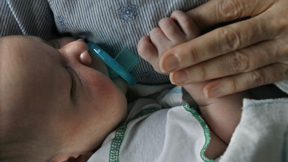 Държач за бебе доброволец носи новородено, което е плачело в
