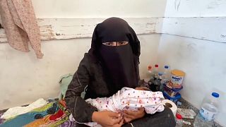 Palesztin nő újszülött gyermekével a gázai Hán-Juniszban 2023. október 28-án