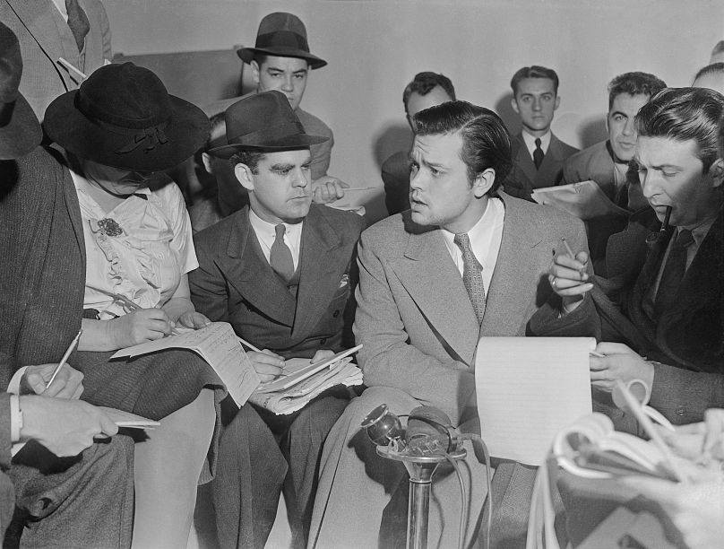 Photo of Orson Welles meeting with reporters in an effort to explain that no one connected with the War of the Worlds radio broadcast had any idea the show would cause panic.