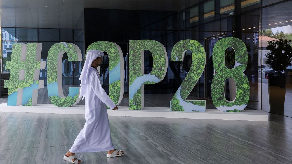 Човек минава покрай знак COP28 по време на събитие в
