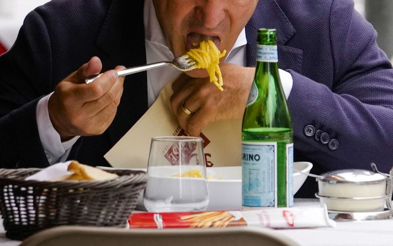 FILE: A man eats pasta in a restaurant in Milan, northern Italy, Thursday, June 8, 2023.