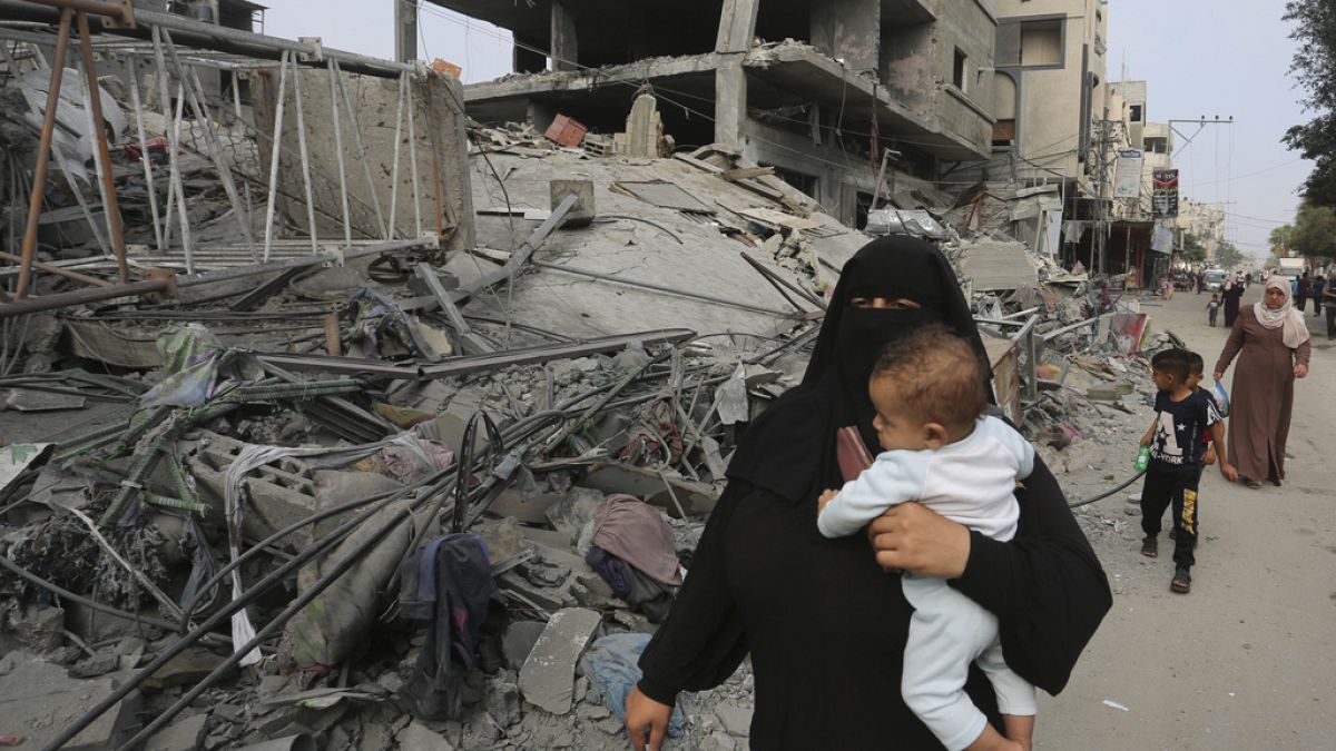 Παλαιστίνια με ένα παιδί στην αγκαλιά στη Ράφα μετά από ισραηλινό βομβαρδισμό