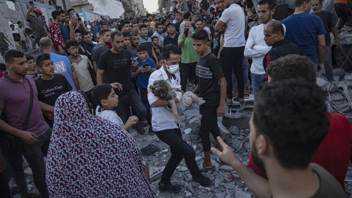 Un bambino viene portato via dalle macerie di un edificio dopo un attacco aereo a Khan Younis, nella Striscia di Gaza. (Sabato 21 ottobre 2023). 