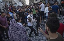 A child is carried from the rubble of a building after an airstrike in Khan Younis, Gaza Strip, Saturday, Oct. 21, 2023. 