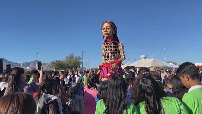 Giant puppet "Little Amal" with crowds near the Mexico-US border