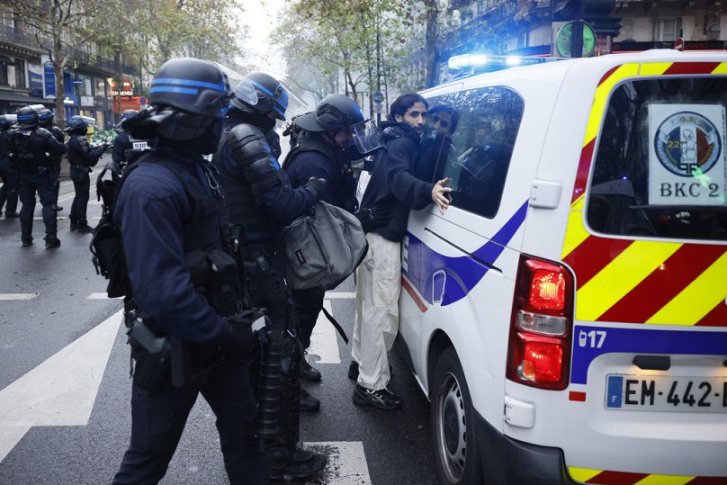 Um manifestante é detido durante a manifestação de solidariedade com o povo palestiniano no sábado, 28 de outubro de 2023, em Paris.