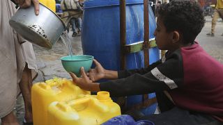 Un palestino llena un vaso con agua potable durante el bombardeo israelí en curso de la Franja de Gaza en Rafah el sábado 28 de octubre de 2023.