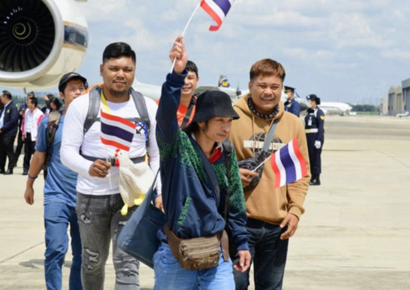 Izraelben dolgozó thai idénymunkások érkeznek a bangkoki nemzetközi reptérre az Izrael és a Hamász között kitört háború után