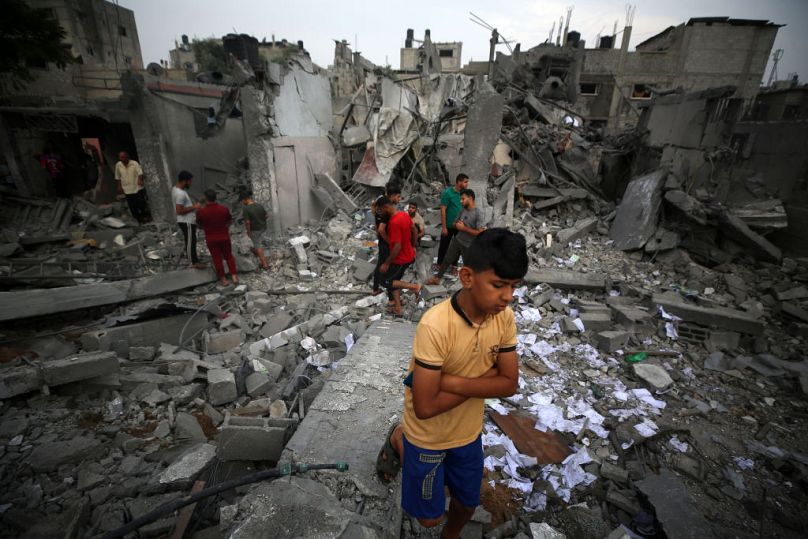 People check the destruction following Israeli strikes in Nuseirat camp in the central Gaza Strip on Sunday