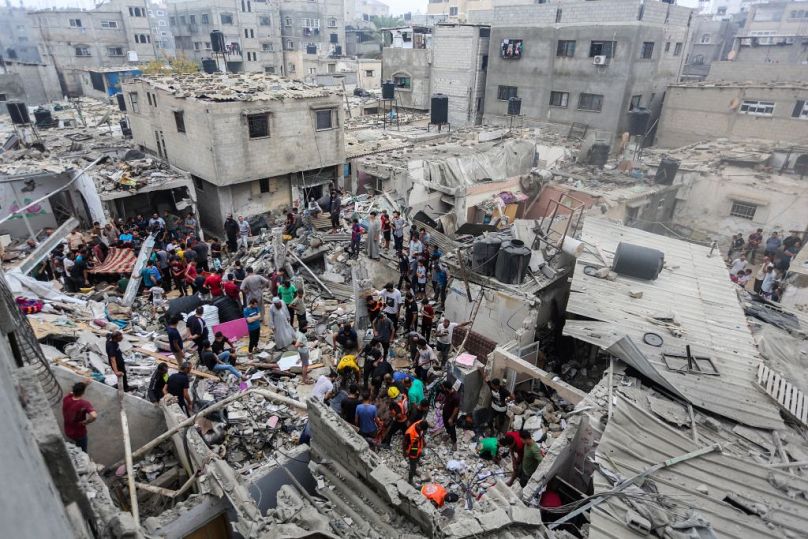 People search through buildings that were destroyed during Israeli air raids in the southern Gaza Strip on Sunday in Khan Yunis, Gaza