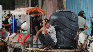 فلسطيني يجلس على عربة يجرها حمار 
