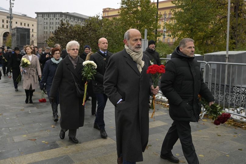 Employees of diplomatic missions walk to lay flowers at the monument where the first camp of the Gulag political prison system was established,in Lubyanska.