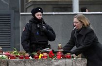 A police officer guards an area as U.S. Ambassador to Russia Lynne Tracy lays flowers at the monument, a large boulder from the Solovetsky islands.