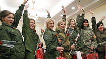 FILE - Russia-backed female rebel fighters wave while posing for media after a beauty contest involving women from the main separatist battalions in Donetsk, Ukraine, 2015.