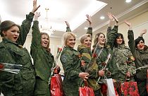 DATEI - Von Russland unterstützte Rebellenkämpferinnen winken, während sie nach einem Schönheitswettbewerb, an dem Frauen aus den wichtigsten separatistischen Bataillonen teilnahmen, in Donezk, Ukraine, 2015 für die Medien posieren.