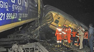 Rescuers and others stand after two passenger trains collided in Vizianagaram district, Andhra Pradesh state, India, Sunday, Oct.29, 2023.