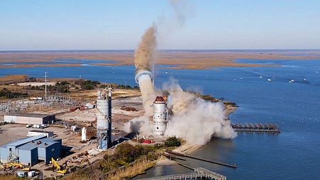The smokestack at the former B.L. England power plant in Upper Township, New Jersey, USA, is toppled during a controlled demolition, Thursday 26 October 2023. 