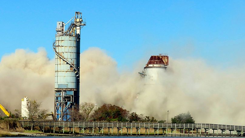 Debris and dust fill the air after smokestack at the former B.L. England power plant in Upper Township, New Jersey, USA was felled during a control demolition.