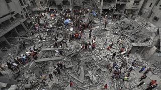 Palestinians inspect the damage of destroyed buildings following Israeli airstrikes on Gaza City, Friday, Oct. 27, 2023.