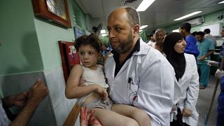 طبيب يحمل طفلة أصيبت خلال غارة إسرائيلية مستشفى كمال عدوان في بيت لاهيا، قطاع غزة. 