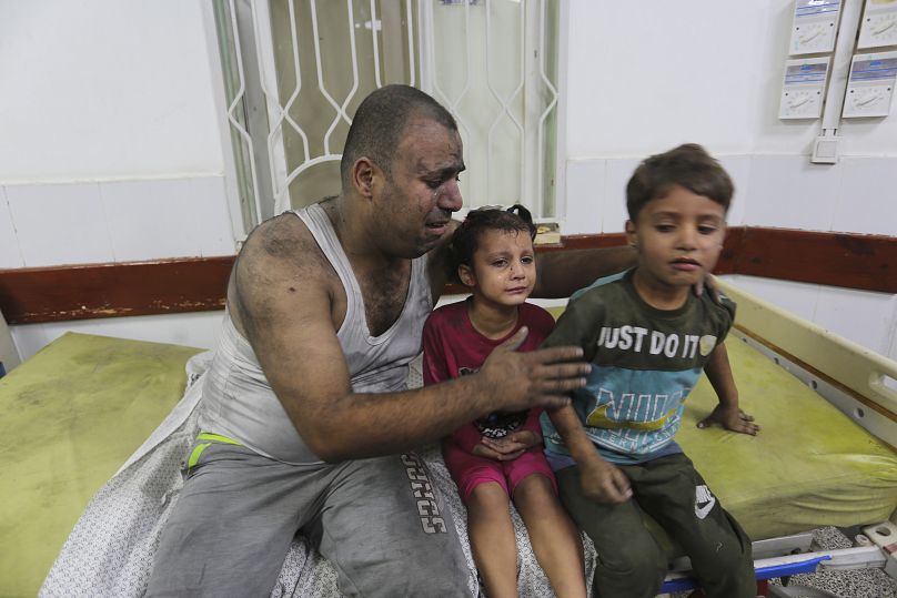 فلسطيني مع أطفاله في مستشفى بغزة