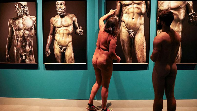 Guide Edgard Mestre talks with Marta, 59, as they take part in a nudist visit to the Archaeology Museum of Catalonia, Barcelona, Spain.