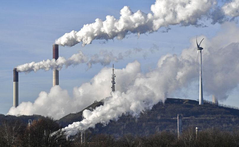 Almanya'nın Gelsenkirchen kentinde bir rüzgar jeneratörünün yanında bir Uniper kömür yakıtlı enerji santrali ve BP rafinerisi buharı.