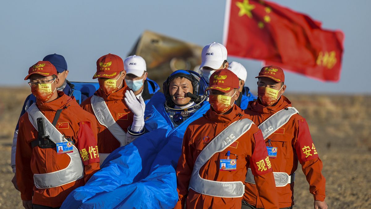 Astronaut Gui Haichao waves as he is carried out of the re-entry capsule of the Shenzhou-14 manned space mission
