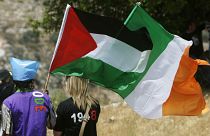 متظاهرون يلوحون بالأعلام الفلسطينية والأيرلندية، في قرية بلعين بالضفة الغربية.
