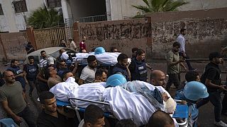 فلسطينيون، بما في ذلك بعض الصحفيين، يحملون جثتي صحفيين فلسطينيين، محمد صبح وسعيد الطويل، اللذين قُتلا في غارة جوية إسرائيلية في مدينة غزة، الثلاثاء 10 أكتوبر 2023.