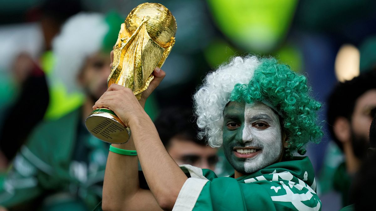 مشجع سعودي يحمل نسخة من كأس العالم 