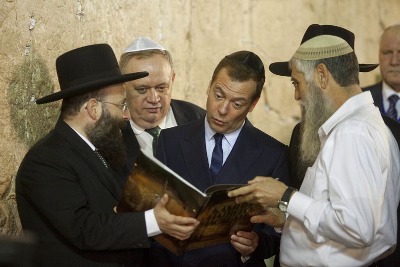 Ex Russian president Dmitry Medvedev receives a book during his visit at the Western Wall, the holiest site where Jews can pray in Jerusalem's Old City, Nov. 10, 2016.