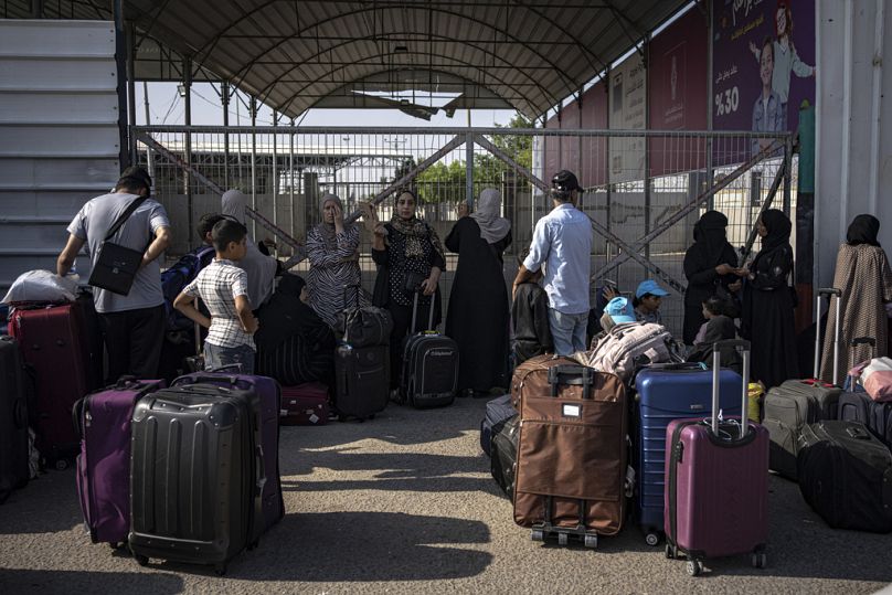 Con todas las pertenencias terrenales, ante le paso fronterizo de Rafah, fuertemente fortificado