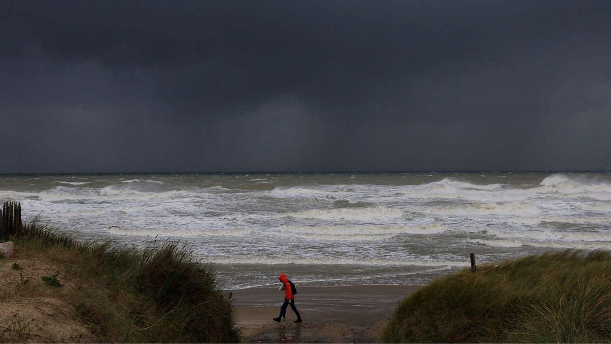 Человек идет по пляжу Ле Портель во время приближения шторма "Киаран", Франция, 1 ноября 2023 г. 