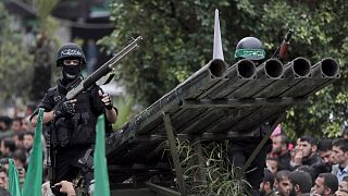 Palestinian Hamas masked gunmen display their military skills during a rally to commemorate the group's 27th anniversary, in Gaza City, on 14 December 2014.
